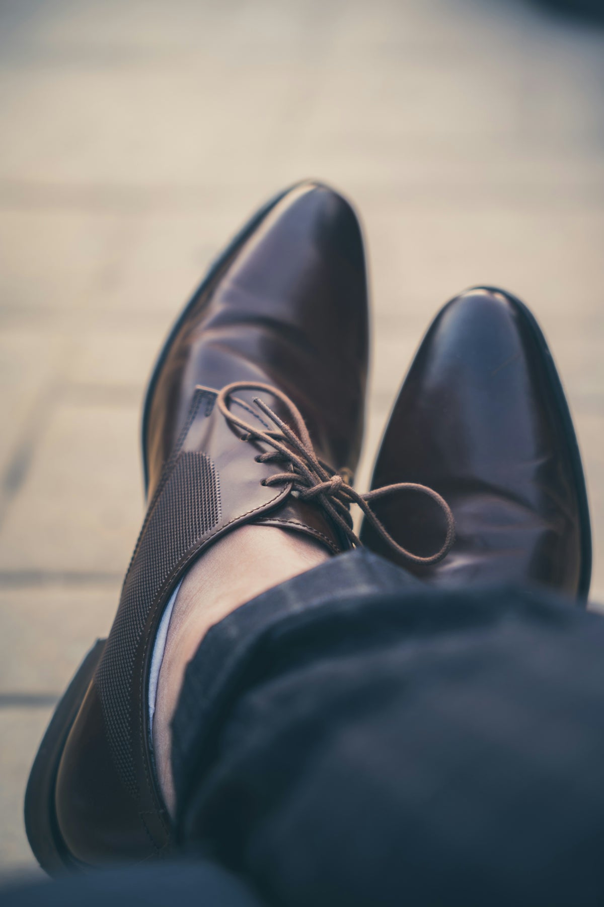 a person's feet wearing a pair of brown shoes