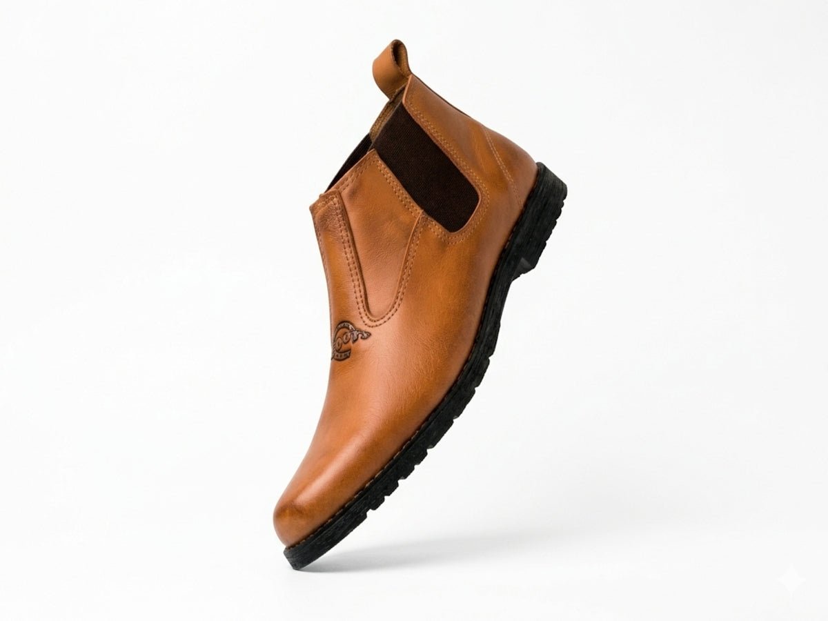 A tan leather chelsea boot against a white background