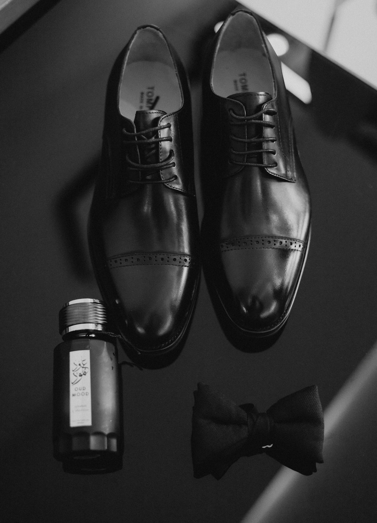 Black dress shoes, cologne, and bow tie