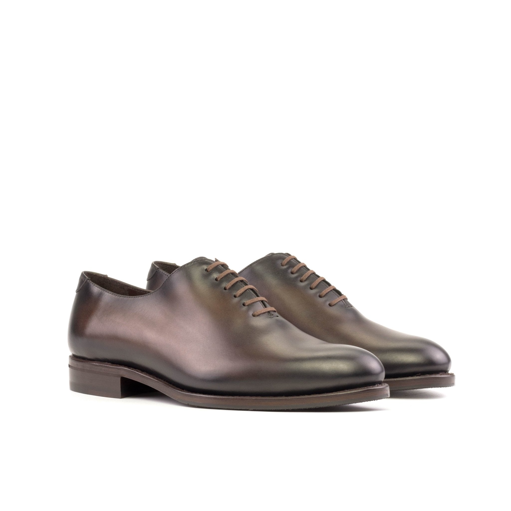 A pair of brown luxury leather oxford shoes with a rounded toe and leather sole.