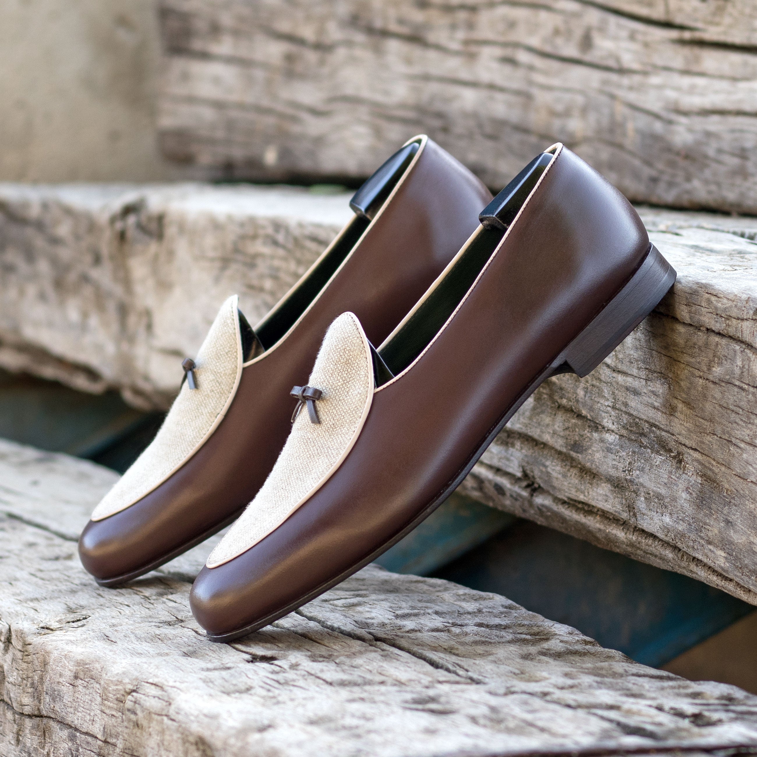 Brown and beige loafers on a wooden surface