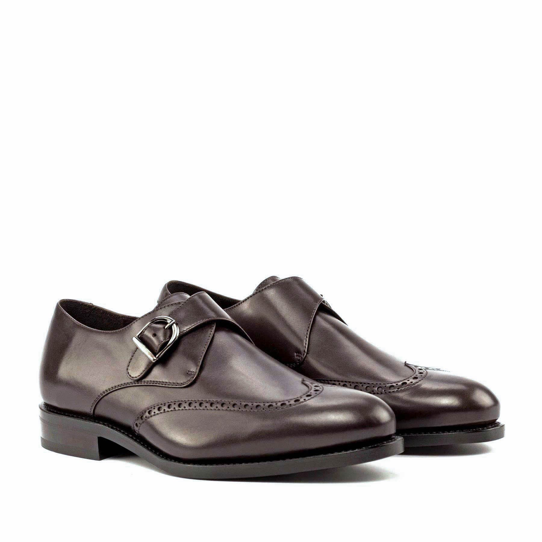 A pair of black classic single monk strap office dress shoes for men with broguing details and a buckle strap.