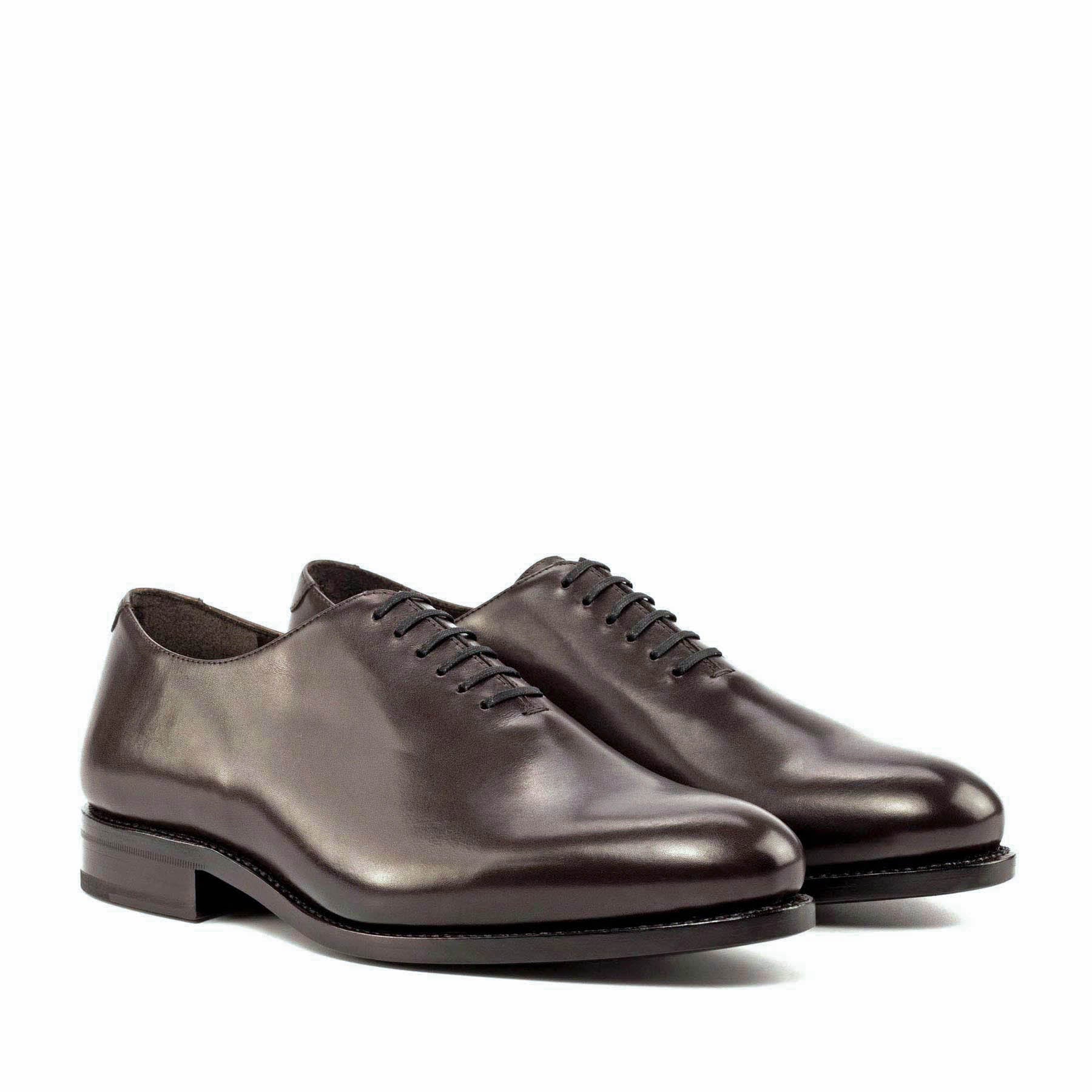A pair of black whole cut leather oxford office dress shoes for men with a traditional round toe and leather sole.