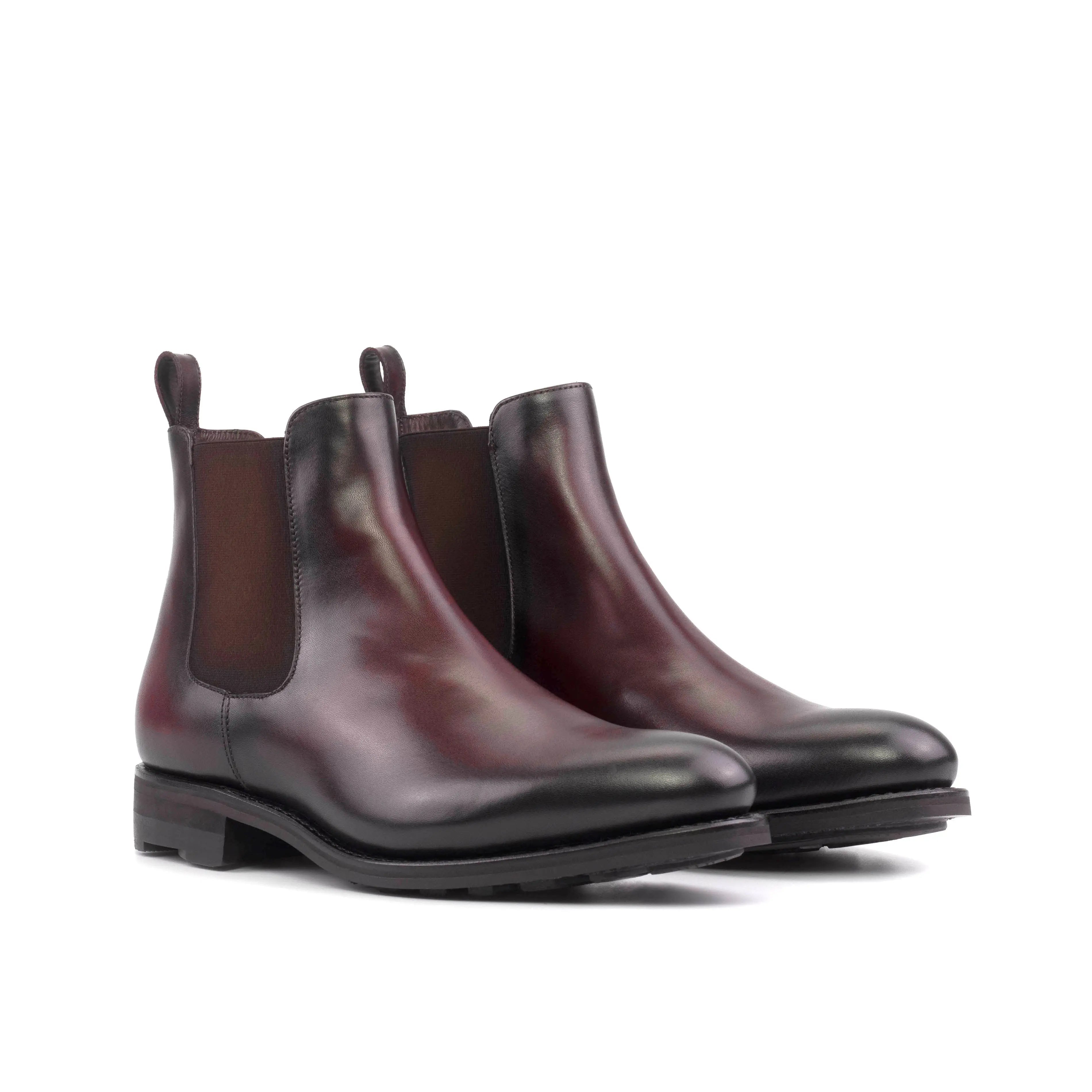 A pair of men's burgundy leather Chelsea boots with a black rubber sole.