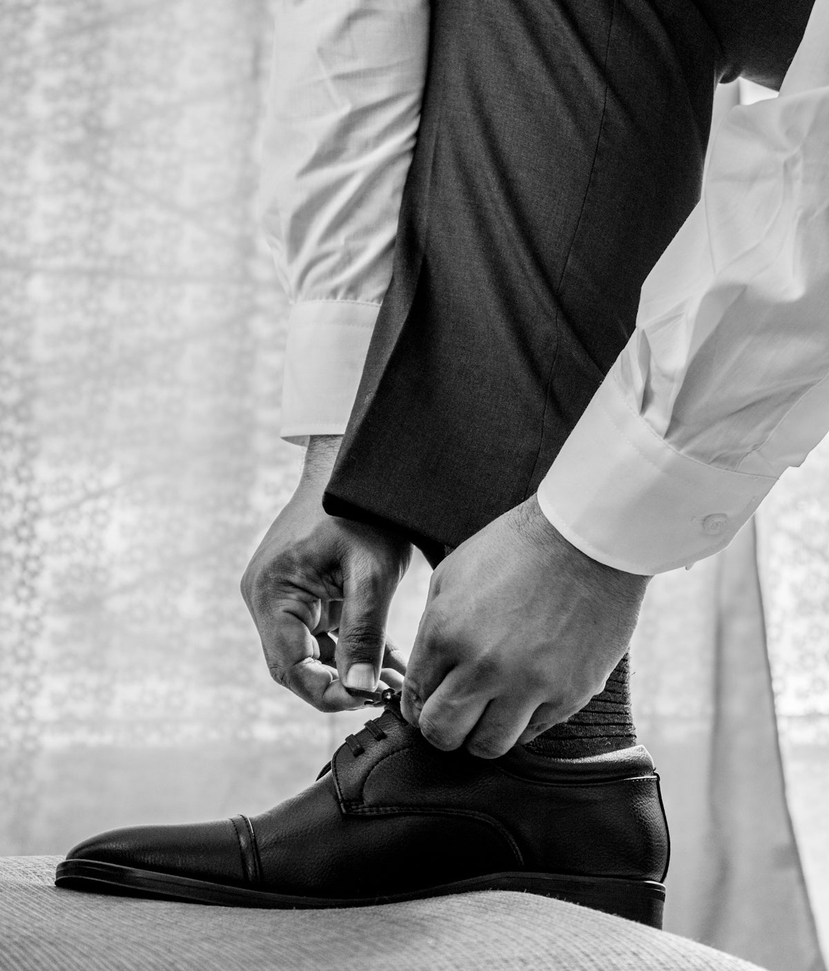 man in white dress shirt and black pants wearing black leather shoes