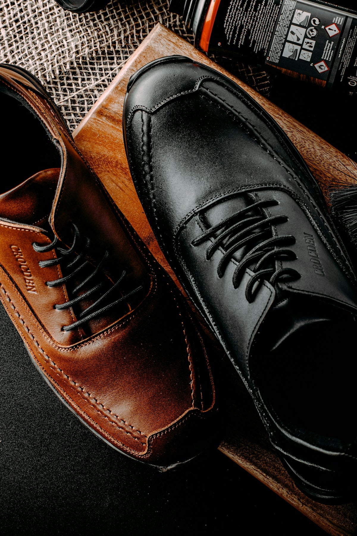 a pair of black and brown shoes sitting on top of a table