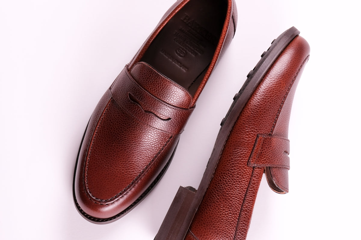 a pair of brown shoes on a white surface