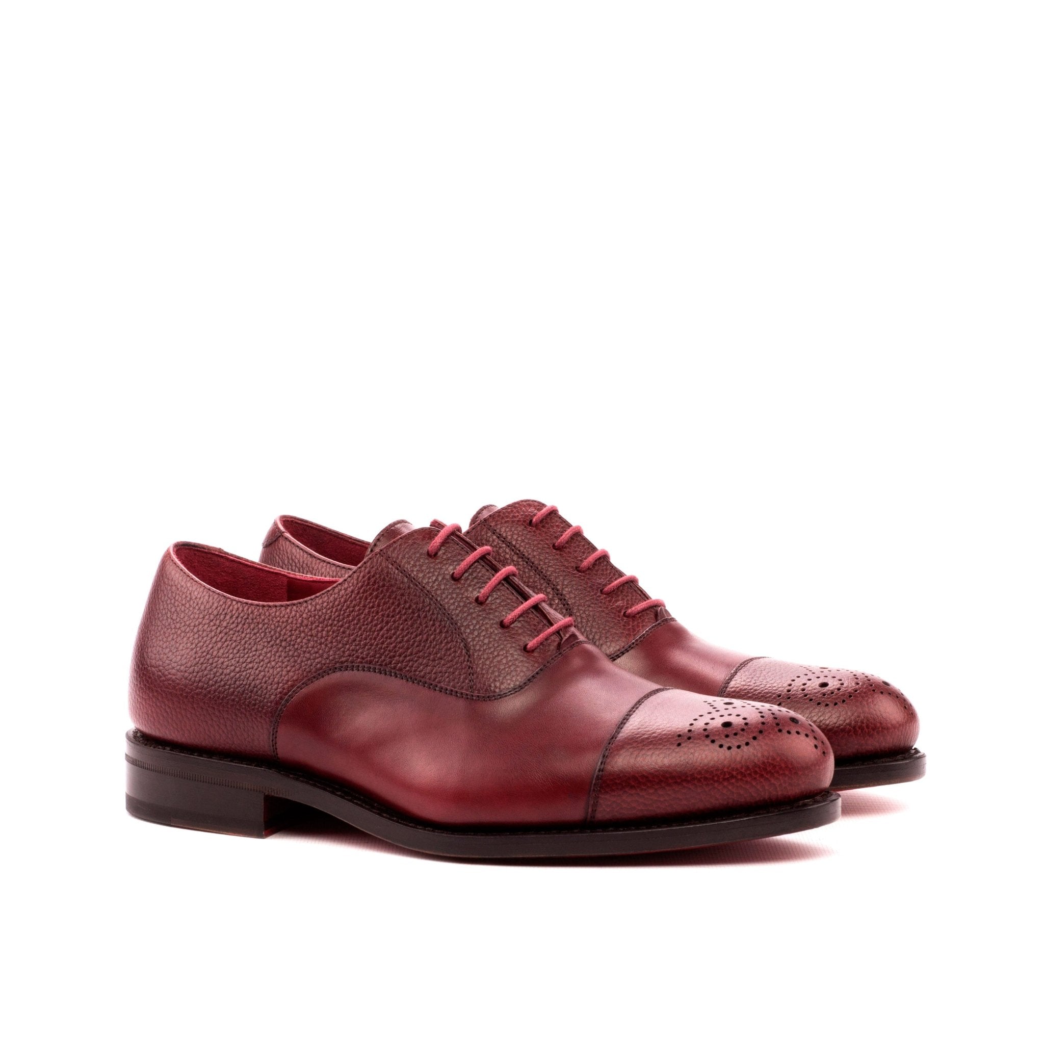 Pair of maroon leather shoes on a white background