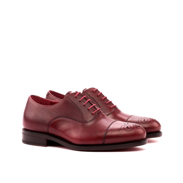 Pair of maroon leather shoes on a white background