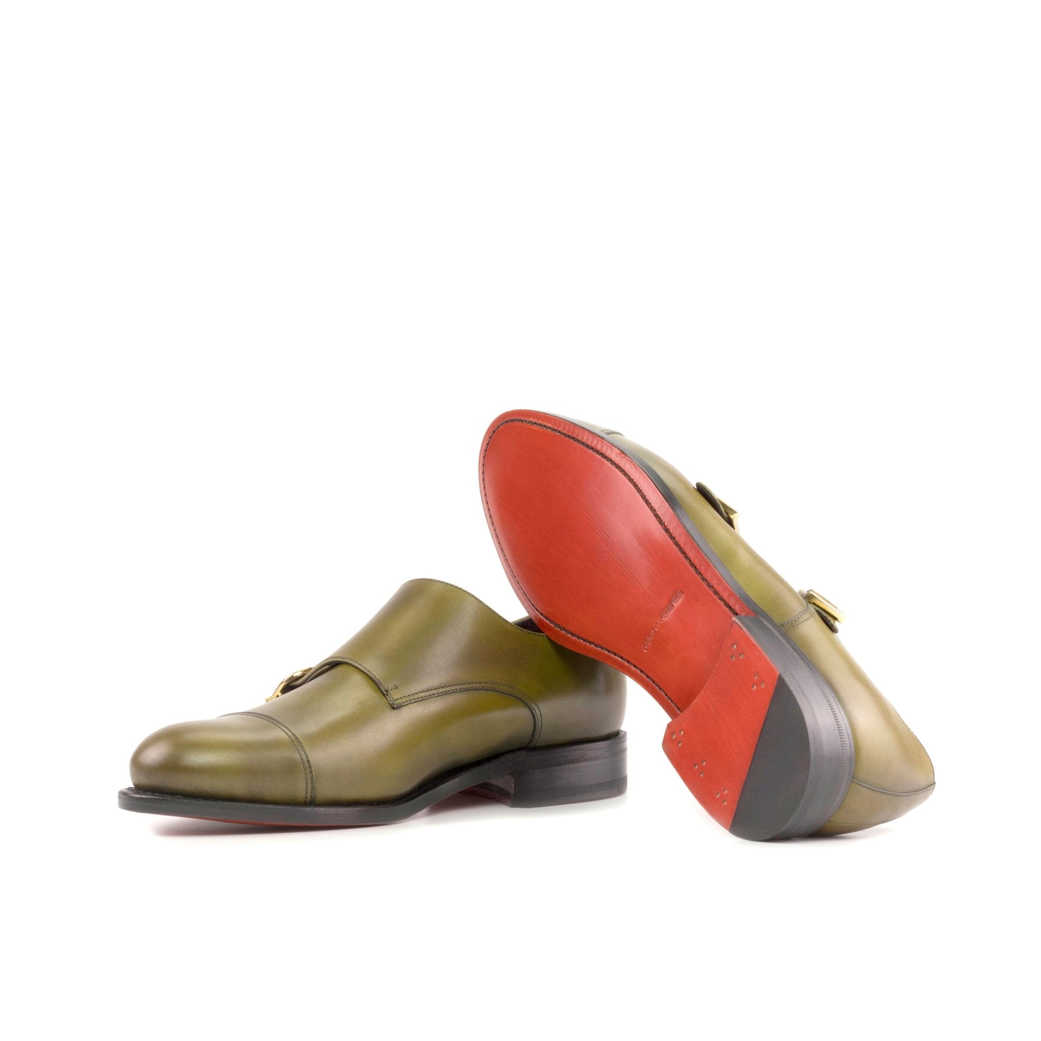 A pair of double monk strap loafer shoes for men with red bottoms, placed against a white background.