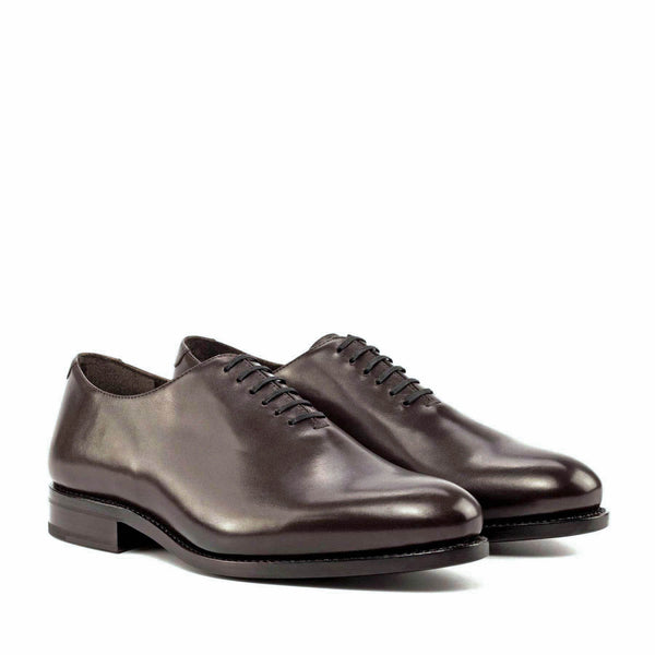 A pair of black whole cut leather oxford office dress shoes for men with a traditional round toe and leather sole.