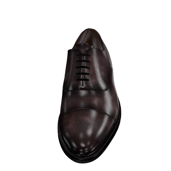Brown leather dress shoe displayed on a computer screen with editing tools.