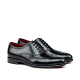 A pair of black brogue Oxford dress shoes with red bottom sole and traditional wingtip design.