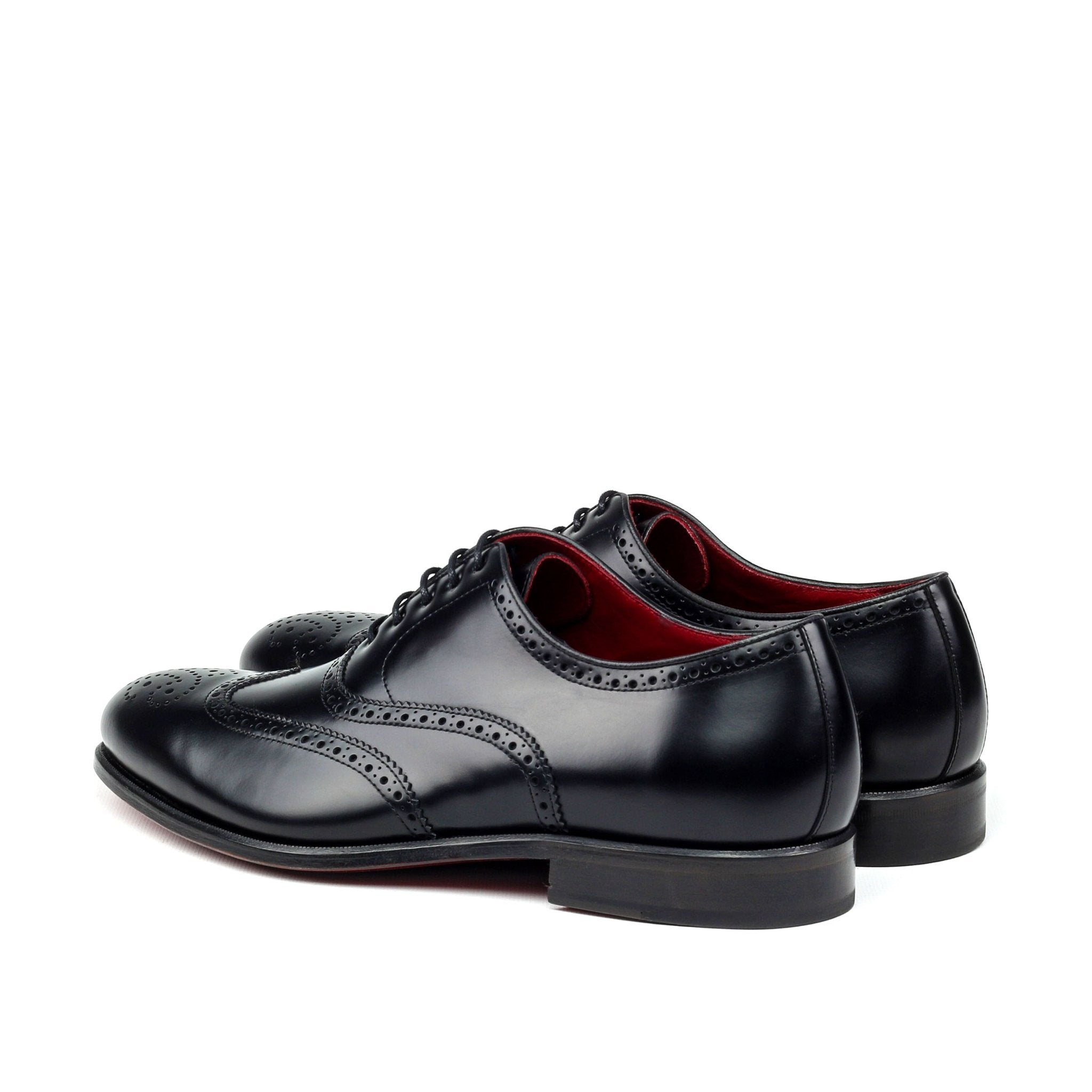 Black dress shoes with red lining on a white background