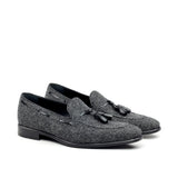 A pair of dark grey flannel tassel loafers with a square toe and low heel.